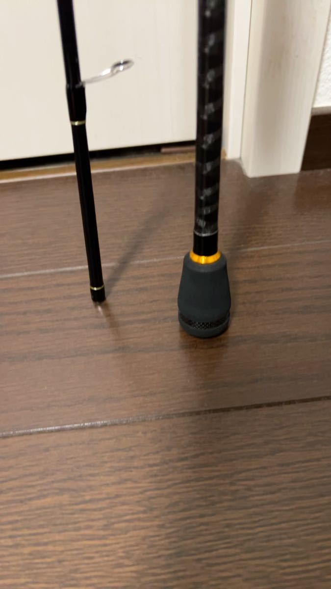 Photo of the lower section and handle of the トリプルクロス ライトゲーム fishing rod (TCX-T732AJI) standing on a wooden floor.
