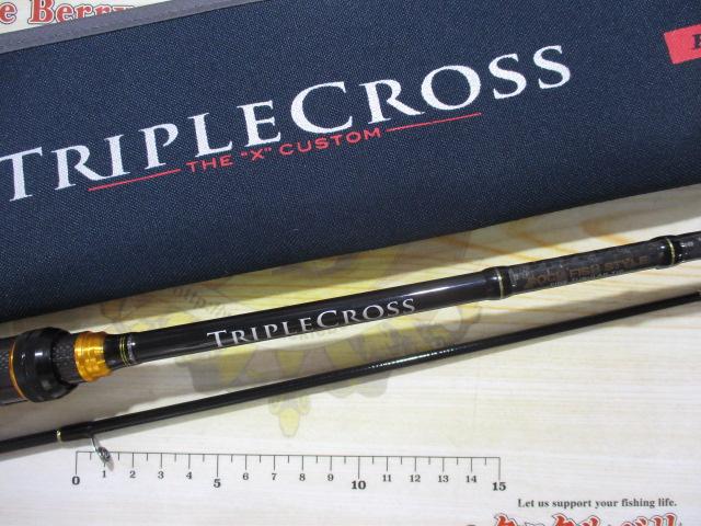 Fishing rod laid flat with its TripleCross sleeve visible, showing the rod blank, handle, and a ruler for scale.