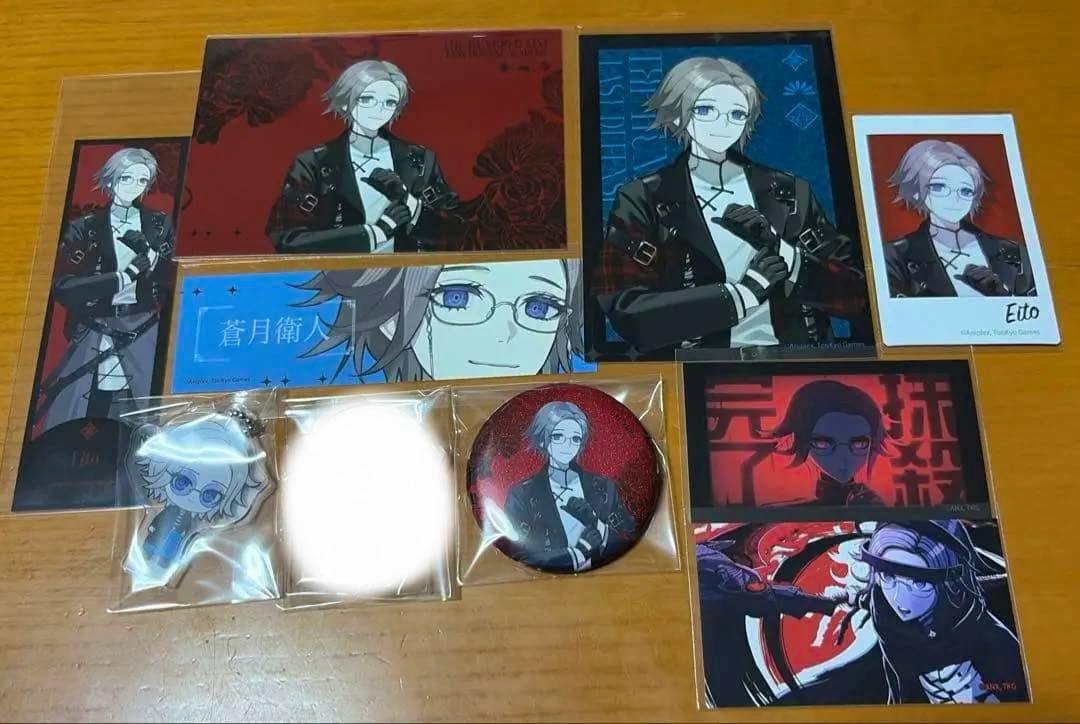 Photo of the 蒼月衛人 チャイナパンク 9-piece set showing an acrylic keychain, badge, and character cards arranged on a wooden surface.