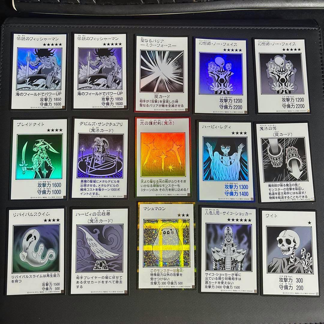 Photo of fifteen monochrome manga-style trading cards arranged in a 3x5 grid on a card binder page.
