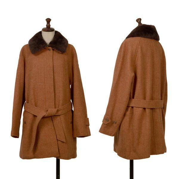 Front and back views of an orange wool women’s jacket with a dark fur collar displayed on a dress form.