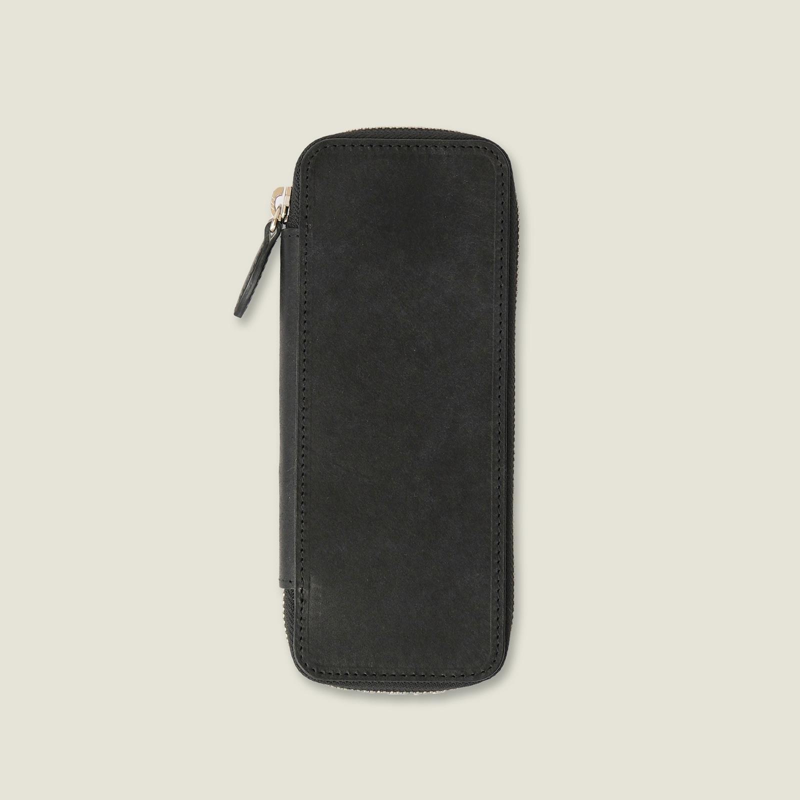 Black leather key case photographed from the front showing the exterior and zipper pull.