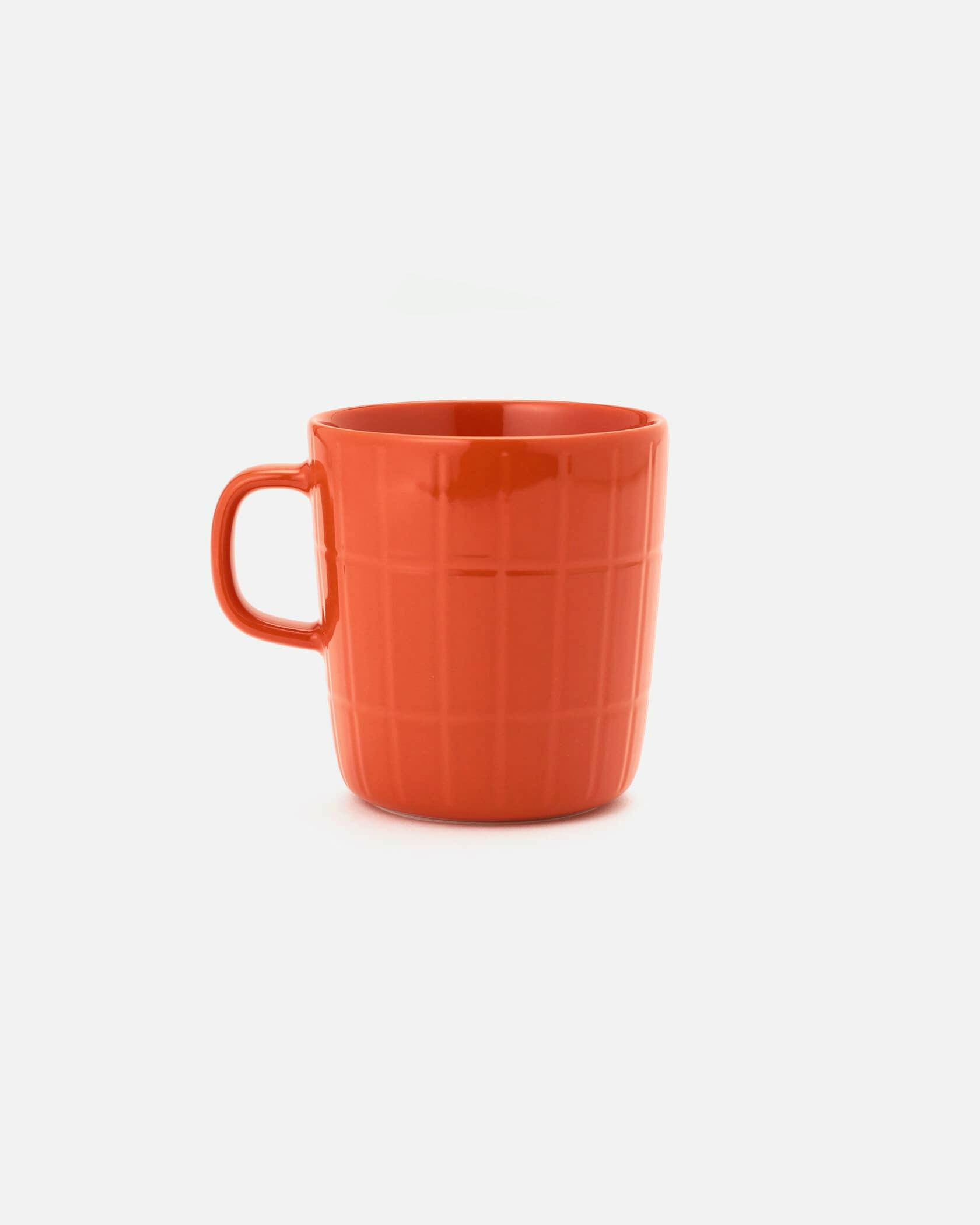 Orange Tiiliskivi ceramic mug with a handle photographed on a white background.