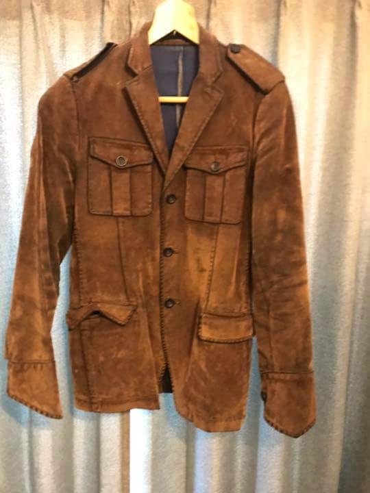 Front view of the MARIO MATTEO vintage-style jacket hanging on a hanger against a curtain background.