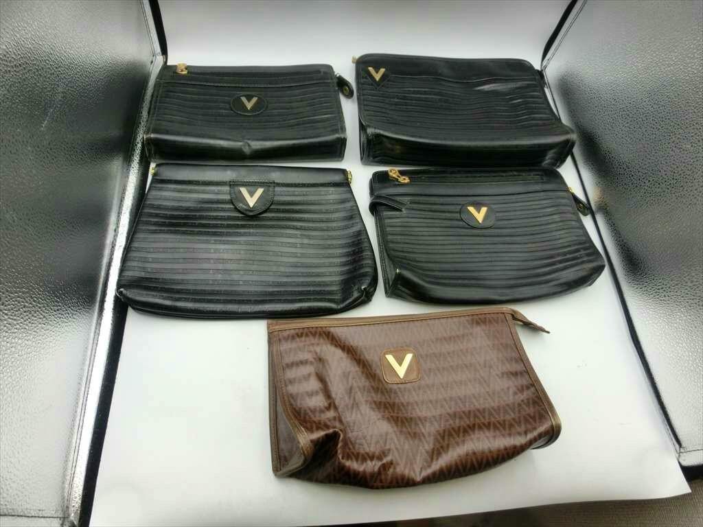 Five leather second bags (four black, one brown) arranged on a white surface.