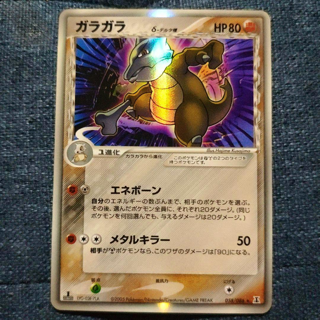 Front photo of the ガラガラ trading card (キラ) centered on a blue fabric background.
