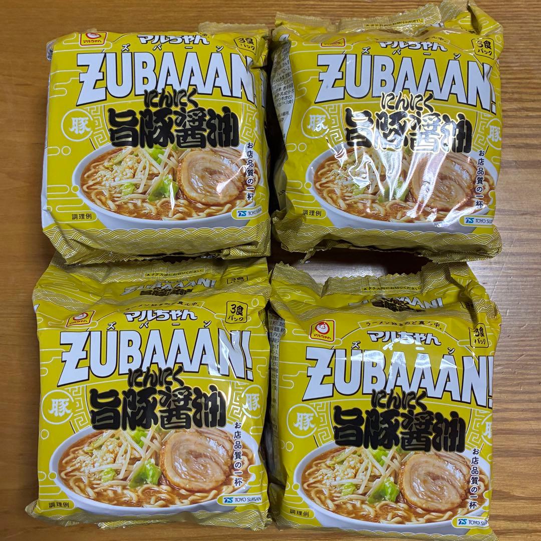 Four yellow packs of ZUBAAAN instant noodles arranged on a wooden surface.