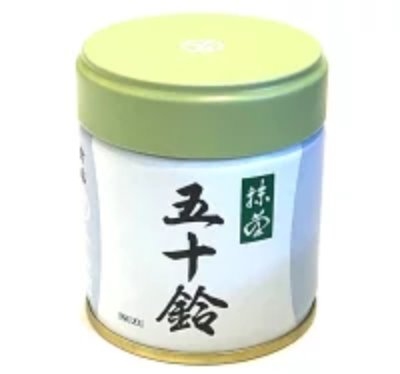 A metal canister of matcha green tea with a light green lid and a white label showing Japanese characters '五十鈴'.