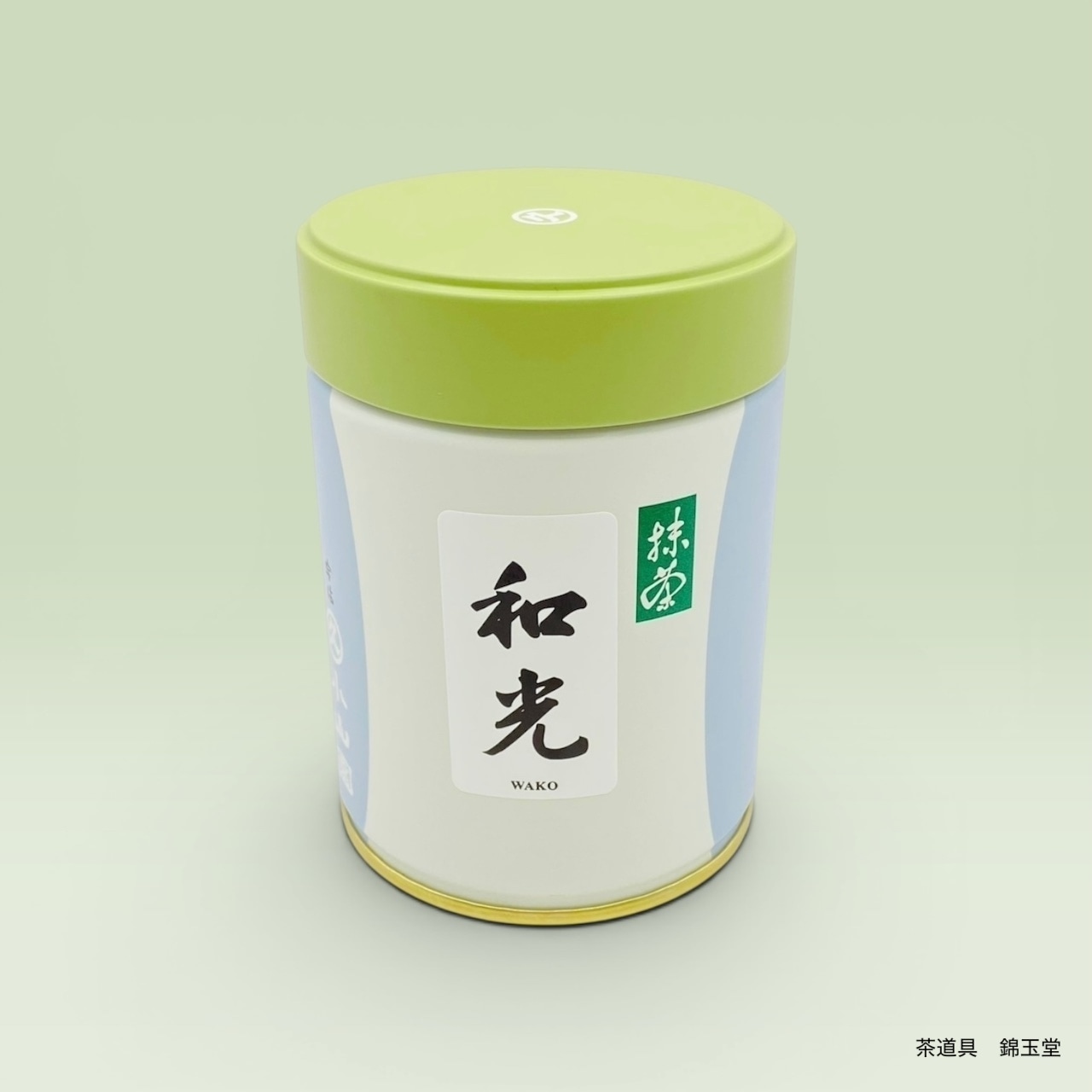 A green-lidded tin can of Matcha Wako 100g with a Japanese label on a pale green background.