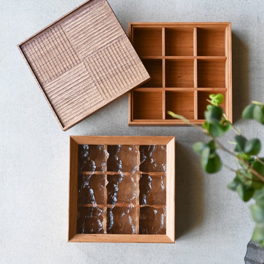 Overhead view of a wooden one-tier accessory case showing the lid, a compartmented tray, and an inner divided insert.