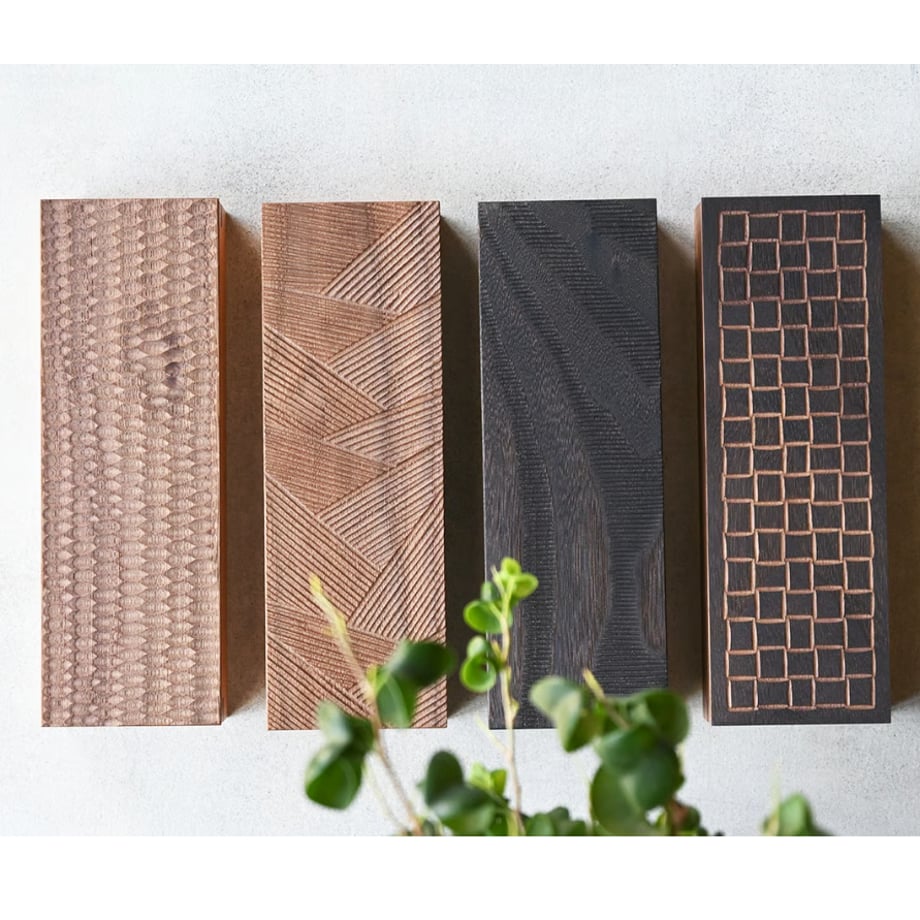 Top-down photo of four rectangular wooden pencil boxes with different carved lid patterns displayed side by side.