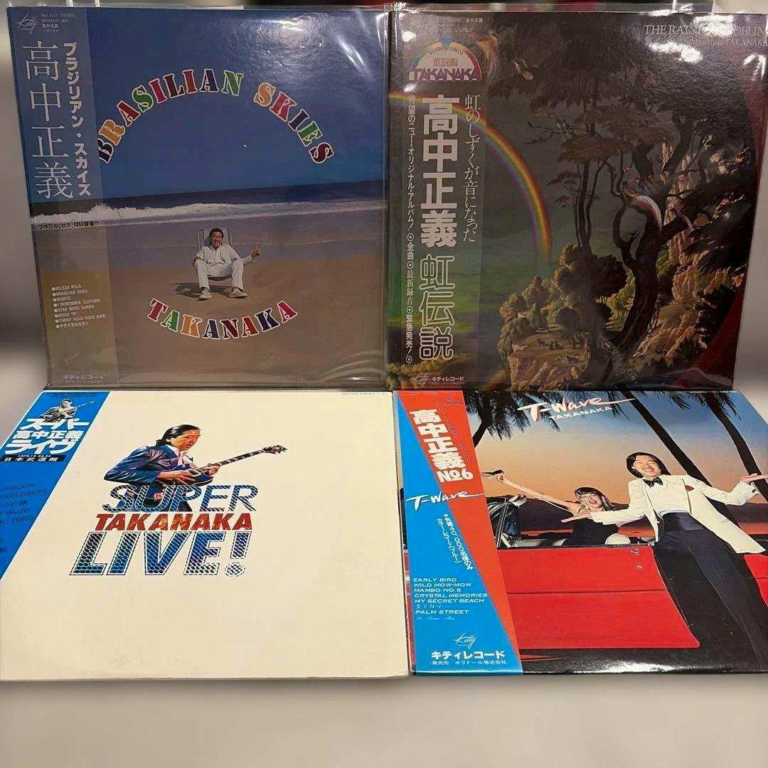 Four Masayoshi Takanaka vinyl record covers arranged two-by-two on a surface, with obi strips visible on some albums.