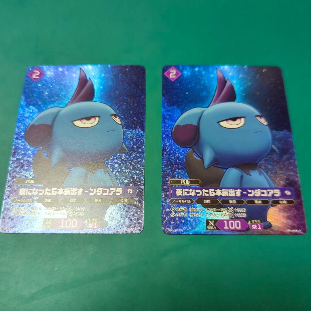 Two trading cards showing the front artwork of the 夜になったら本気出す-ンダコアラ promo cards placed on a green surface.