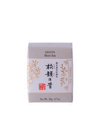 Front view of a 20g boxed matcha green tea product with Japanese text and decorative gold botanical design on a black background.