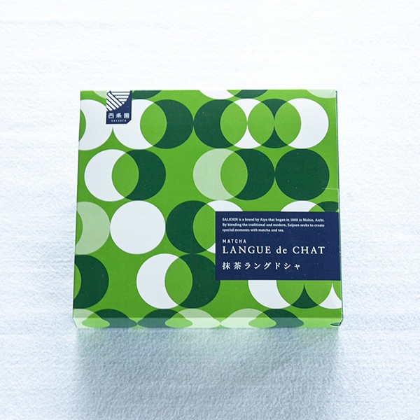 A green patterned box of matcha langue de chat cookies shown from above.