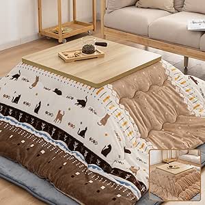 Reversible beige and brown kotatsu comforter with cat and geometric patterns draped under a low wooden table in a living room setting.