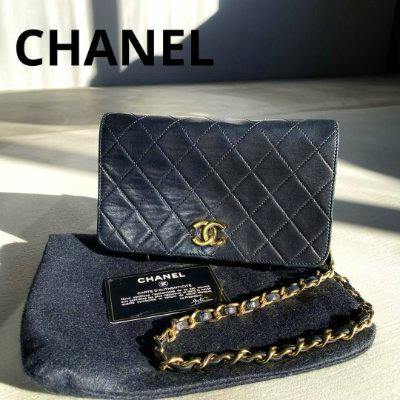 Front view of a black matelassé leather chain shoulder bag with a gold CC clasp, chain strap, dust bag, and authenticity card visible.