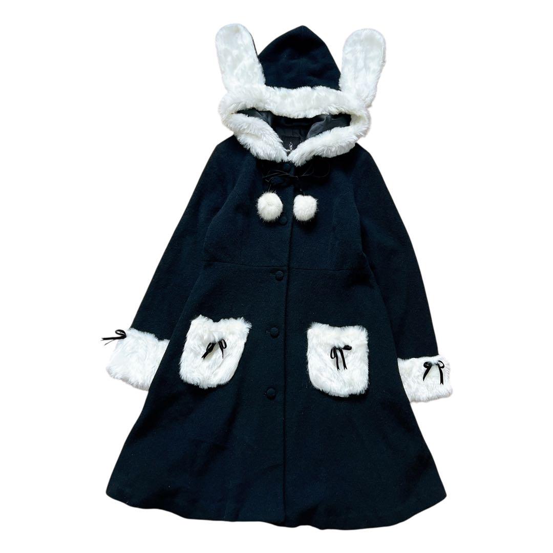 Flat-lay of a women's polyester long coat with bunny-ear hood, white fur trim, pocket bows, and pom-pom ties.