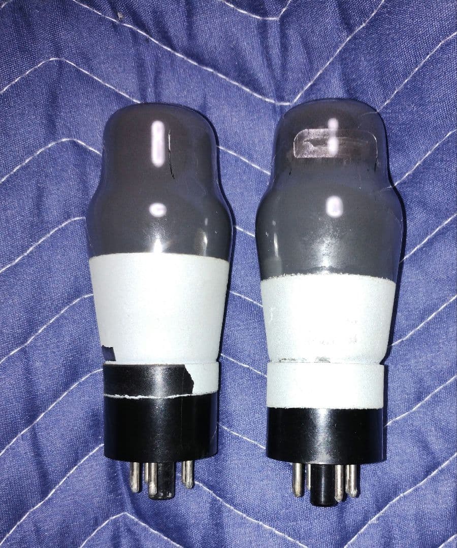 Two used MAZDA 6P25 beam power vacuum tubes shown side-by-side on a blue fabric background.