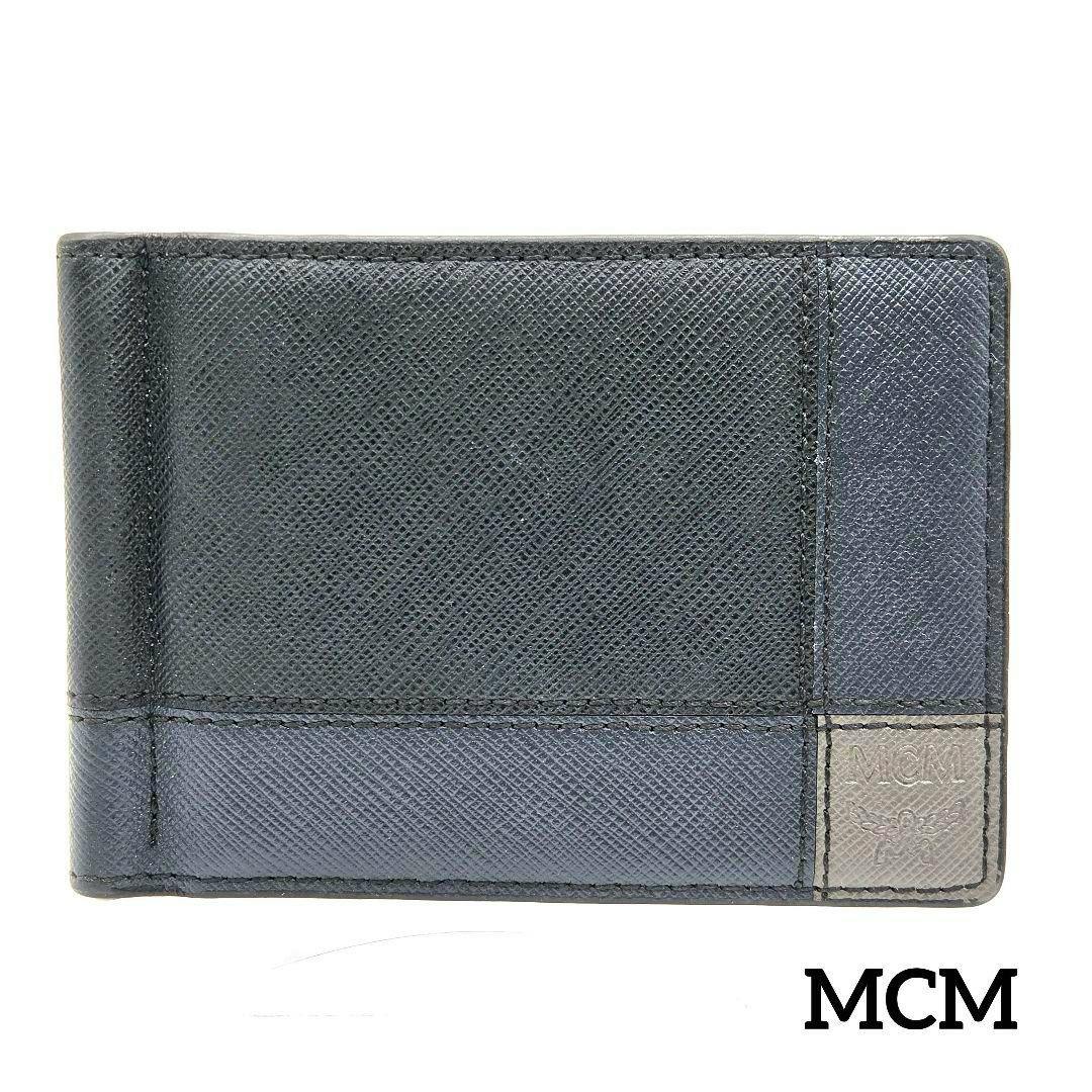 Black textured MCM bi-fold money-clip card case shown closed with an MCM logo patch at the bottom-right.