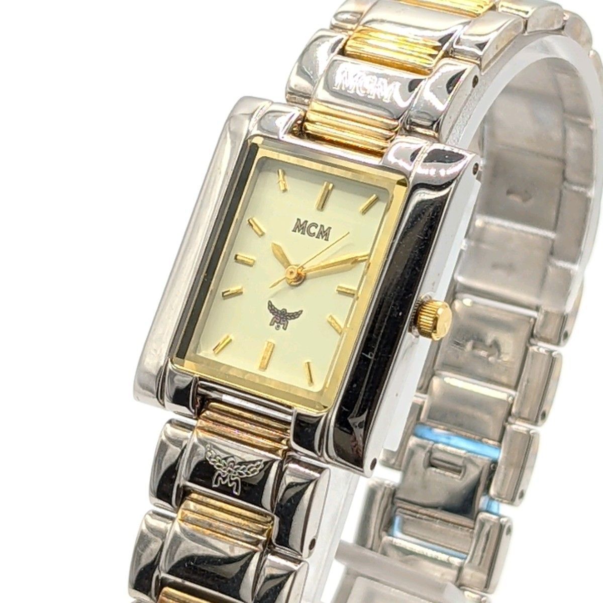 Two-tone gold and silver MCM men's square quartz watch with a rectangular cream dial and metal link bracelet.