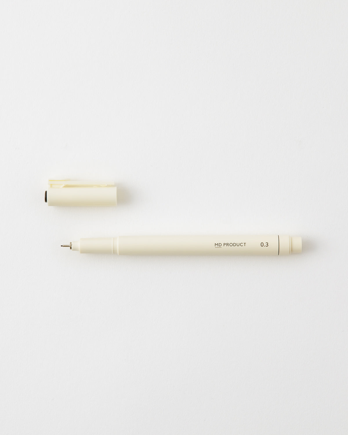 A cream-colored MD Drawing Pen (ballpoint) with its cap removed, shown on a white background.