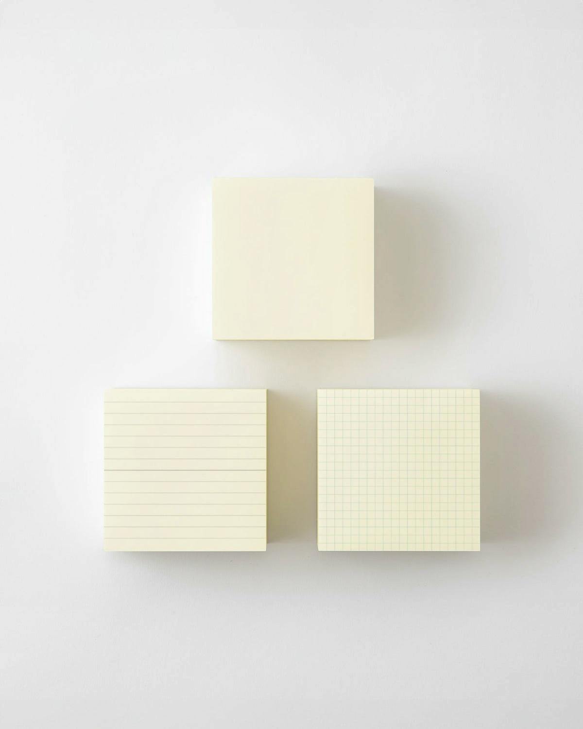 Three MD Memo Block pads arranged on a white surface showing a blank pad, a lined pad, and a grid pad.