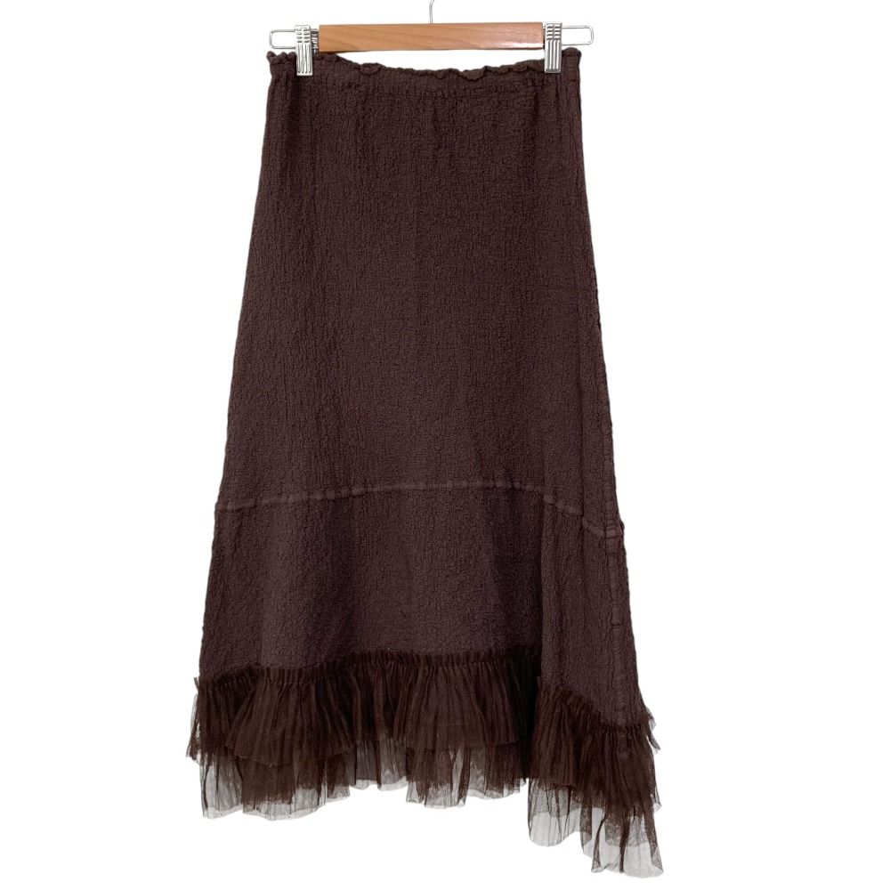 Brown pleated flared women’s skirt hanging on a wooden hanger against a white background.