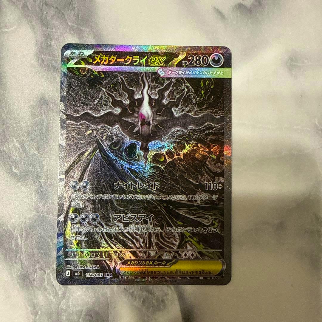 Front of the メガダークライex trading card showing holographic foil artwork and card text.