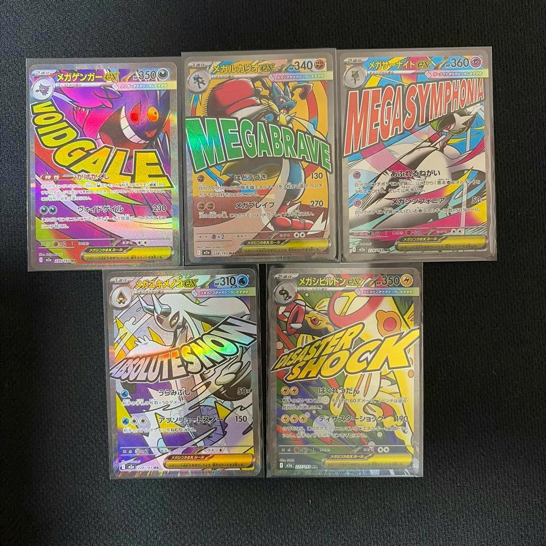 Front sides of five Pokémon trading cards from the メガゲンガーex MA MEGA set shown in protective sleeves on a black surface.