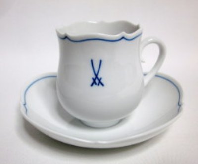 White porcelain coffee cup and matching saucer showing a blue crossed-swords Meissen mark.