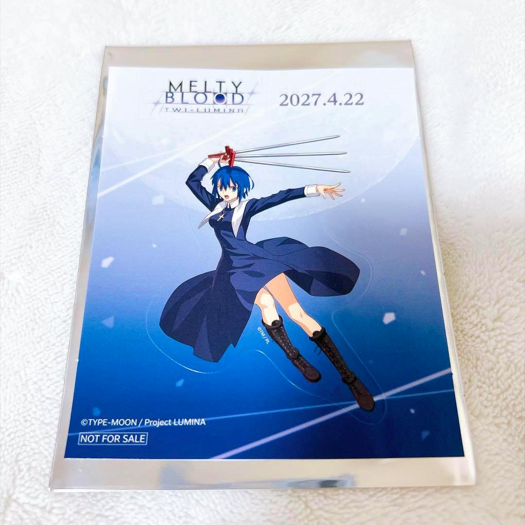 Photo of the MELTY BLOOD:TWI-LUMINA Ciel paper sticker showing the character in a blue dress wielding multiple blades on a blue background with logo and date.