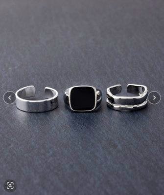 Three men's adjustable non-precious metal rings displayed on a dark gray background.