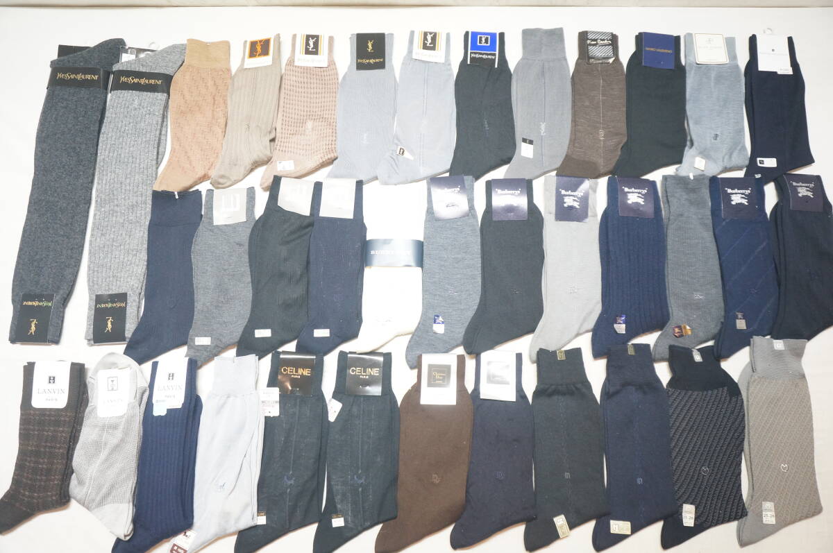Thirty-seven men's socks in assorted colors and brands laid out in rows on a flat surface.
