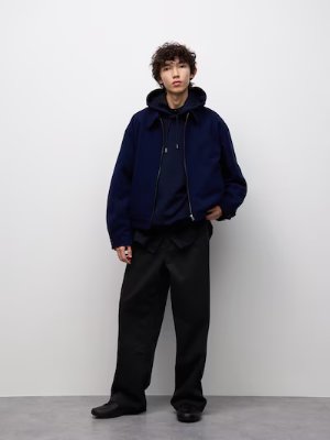 Male model wearing black wide straight chino pants.