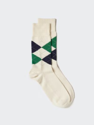 Men's cotton argyle socks in cream with navy and green diamond pattern laid flat on a light background.