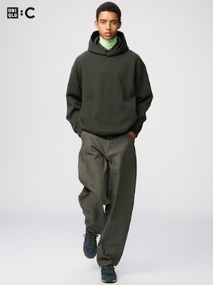 A model wearing the men's barrel jeans in a full-length studio shot, paired with a dark hoodie.