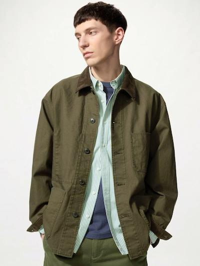 Male model wearing an olive-green men's coverall jacket layered over shirts.