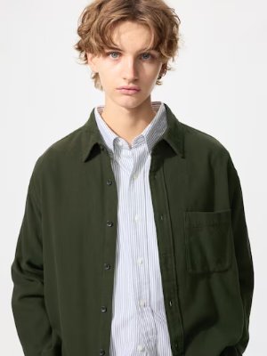 Male model wearing an olive-green men's flannel shirt with a chest pocket over a striped shirt.