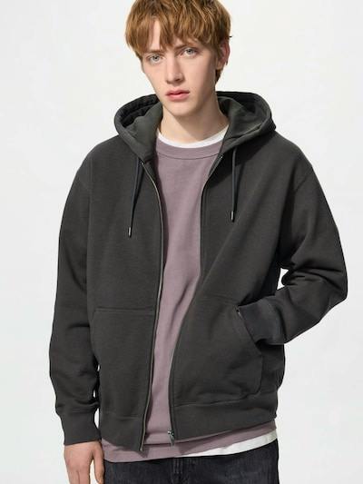 Male model wearing a dark cotton full-zip hooded sweatshirt with front pockets.