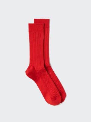 A pair of red men's cotton socks laid flat on a light background.