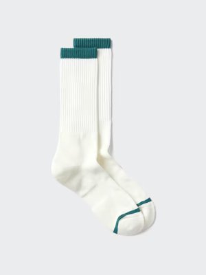 A pair of men's white sports socks with green cuff and toe stripes laid flat on a light background.