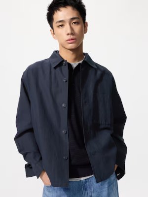 Male model wearing the men's short utility jacket with buttons and long sleeves.