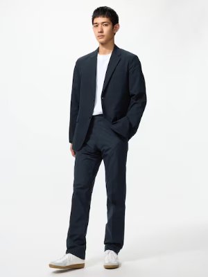Male model wearing a dark men's jacket and matching trousers over a white T-shirt.