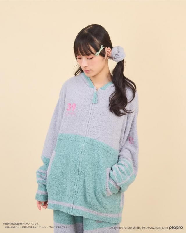 Model wearing a pastel two-tone zip-up polyester men's sweatshirt (roomwear) with front pockets.