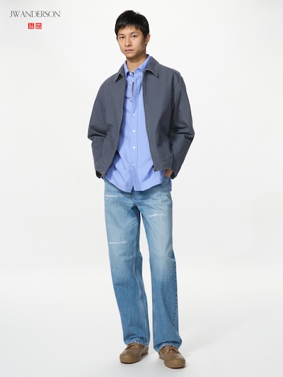 Male model wearing light blue straight jeans against a white background.