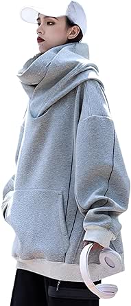 Model wearing a light gray high-neck hooded cotton sweater with a front pocket and loose, oversized cut.