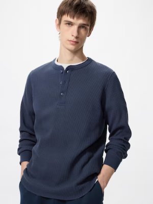 Male model wearing a long-sleeve waffle henley-neck men's cotton T-shirt in navy.