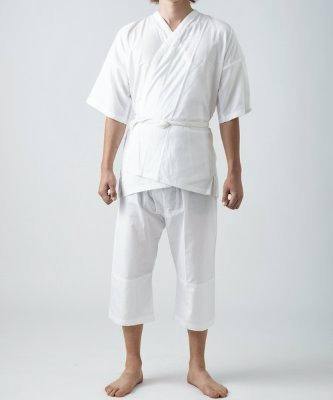 Male model wearing a white men's innerwear set (undershirt and knee-length pants) standing against a plain background.