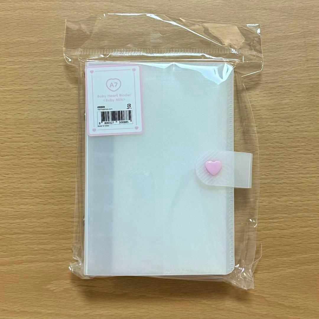 Plastic-packaged translucent white A7 binder with a pink heart clasp visible on the front and a small product label.